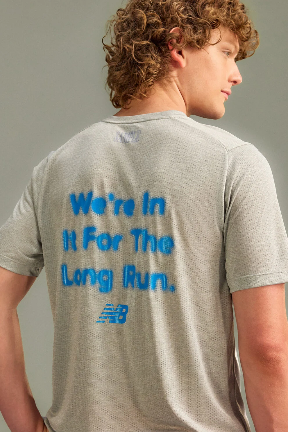 The person is wearing a light gray, short-sleeve athletic T-shirt with breathable mesh texture. 